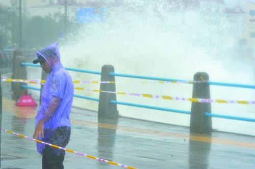 图片说明：9日，“利奇马”在浙江省温岭市石塘镇金沙滩海边掀起巨浪。11日，一名协警在青岛海边维持秩序。